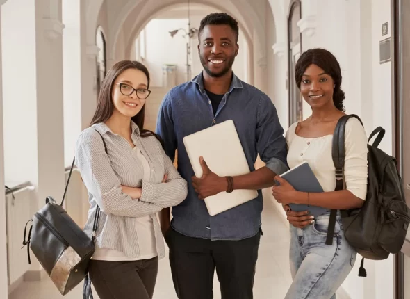 three students holding notebook